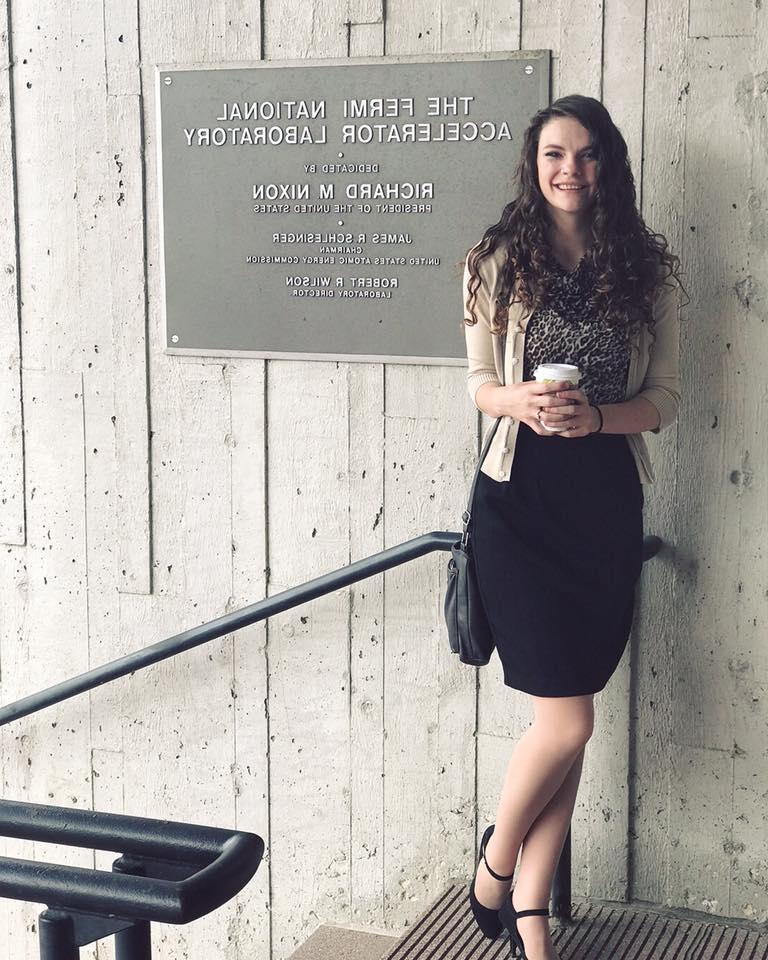 Deborah poses in front of Fermilab sign